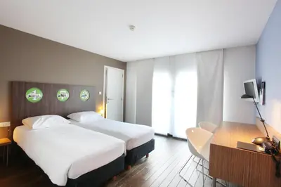a hotel room with two beds and a television at Hotel De Pits in Heusden - Zolder