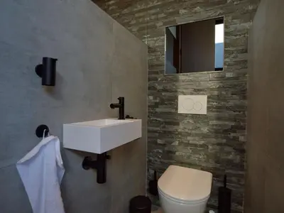 a bathroom with a sink and a toilet and a mirror at Dalhem Villa with Garden in Dalhem