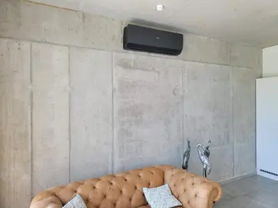 a living room with a couch and a tv on a wall at Dalhem Villa with Garden in Dalhem