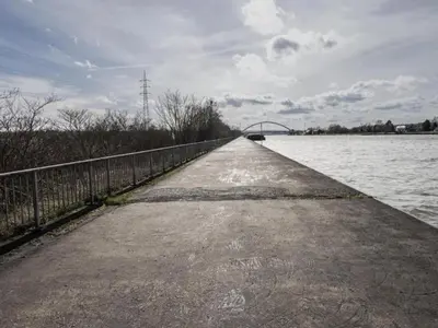 a long walkway next to a body of water at Dalhem Villa with Garden in Dalhem