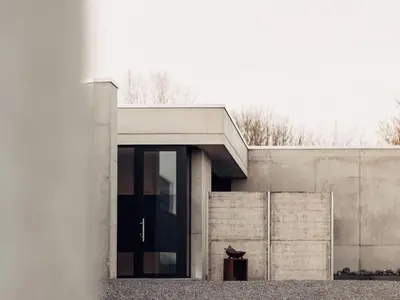 a concrete house with a glass door on it at Dalhem Villa with Garden in Dalhem