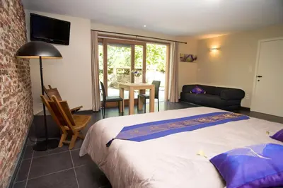 a bedroom with a bed and a living room at De kiezel in Hasselt