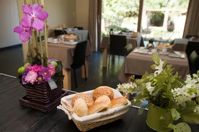 a basket of bread sitting on a table with flowers at De kiezel in Hasselt