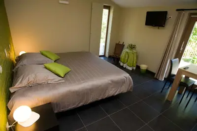 a bedroom with a bed with green pillows and a table at De kiezel in Hasselt
