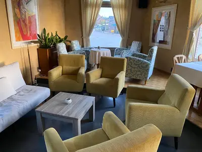 a living room with couches and chairs and a table at Hotel Hooghuys in Hamont-Achel
