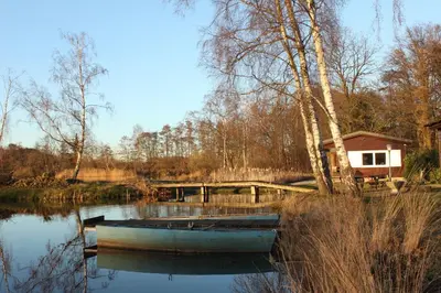 a boat sitting in the water next to a house at My Secret Garden in Diepenbeek