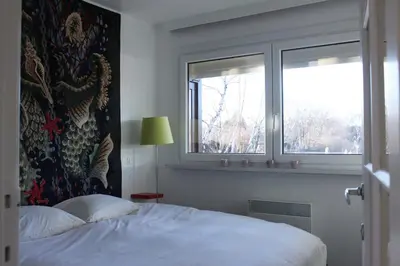 a bedroom with a bed and two windows at My Secret Garden in Diepenbeek