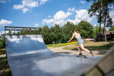 a woman riding a skateboard on a ramp at Familiepark Goolderheide in Bocholt