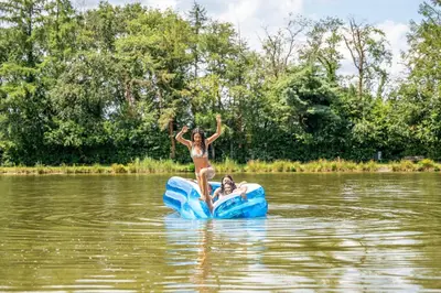 a woman jumping off a raft in a lake at Familiepark Goolderheide in Bocholt