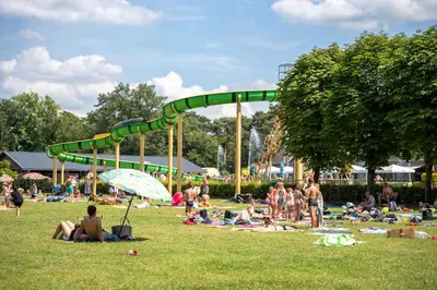 a group of people in a park with a roller coaster at Familiepark Goolderheide in Bocholt