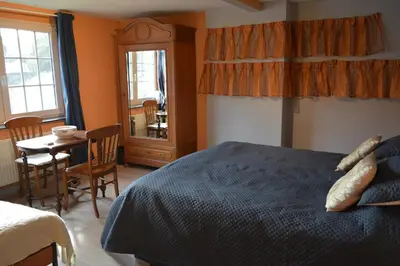 a bedroom with a bed and a table and chairs at Julienne5 in Blégny