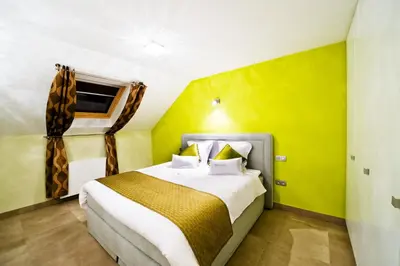a bedroom with a bed and a yellow wall at B&B Villa Curtricias in Kortessem