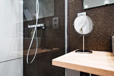 a bathroom with a shower with a mirror on a counter at B&B Villa Curtricias in Kortessem