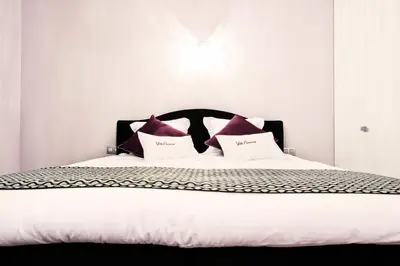 a bed with purple and white pillows on it at B&B Villa Curtricias in Kortessem