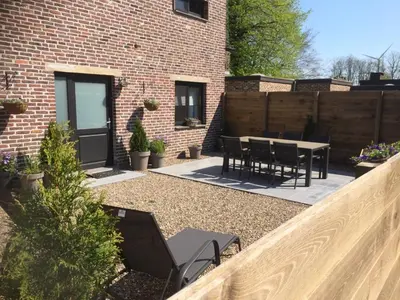 a backyard with a table and chairs and a fence at Villa van Brienen in Dilsen-Stokkem