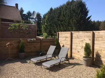 a patio with two chairs and a fence at Villa van Brienen in Dilsen-Stokkem