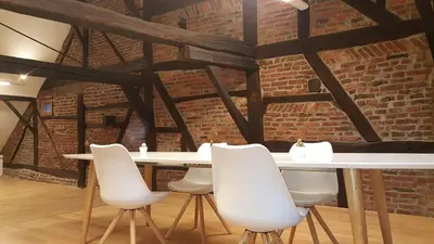 a white table and chairs in a room with a brick wall at The Mind Box in Liège