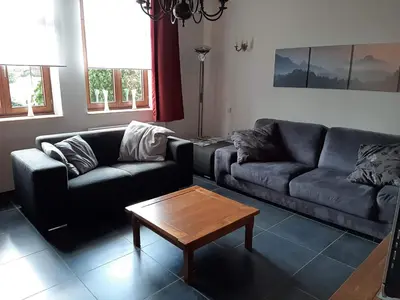 a living room with two couches and a coffee table at Vakantiewoning Het Oude Laer in Bilzen