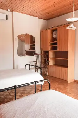a bedroom with two beds and a cupboard and chairs at Vakantiewoning Het Oude Laer in Bilzen