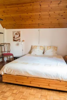 a bedroom with a large bed with a wooden ceiling at Vakantiewoning Het Oude Laer in Bilzen