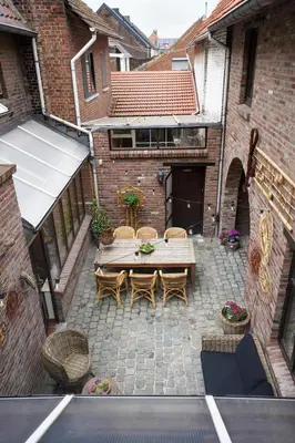 an overhead view of a patio with a wooden table and chairs at De Mandenvlechter in Dilsen-Stokkem