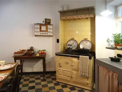 a kitchen with an old stove and a table at B&B Hostellerie Marie in Eben-Emael