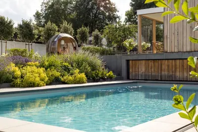 a swimming pool in a garden with a house at B&B Hostellerie Marie in Eben-Emael