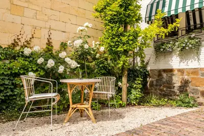 a table and two chairs sitting next to a building at B&B Hostellerie Marie in Eben-Emael