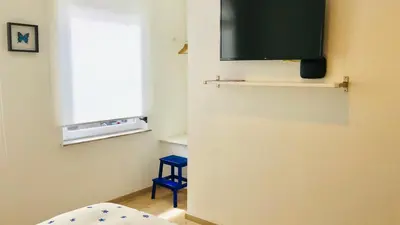 a room with a television and a blue stool at Lyves Two in Liège