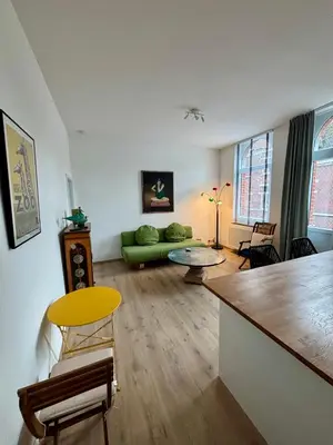a living room with a green couch and a table at Lyves Two in Liège