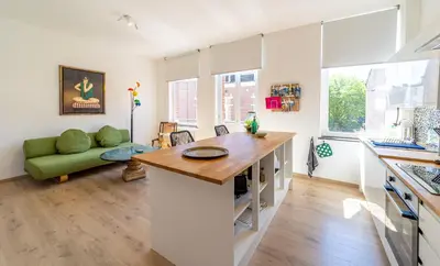 a kitchen and living room with a green couch at Lyves Two in Liège