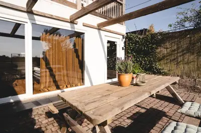 a wooden table on the patio of a house at Maas Suites (Maastricht - Lanaken) in Lanaken