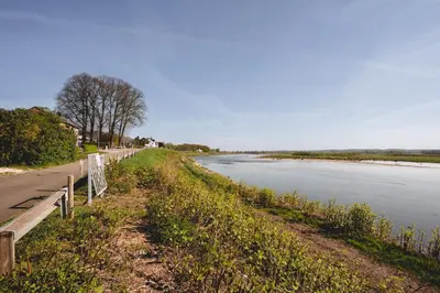 a road next to a river with a fence at Maas Suites (Maastricht - Lanaken) in Lanaken