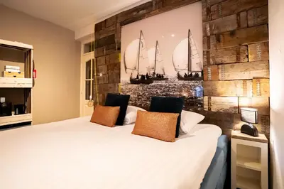 a bedroom with a large white bed with sails on the wall at Maas Suites (Maastricht - Lanaken) in Lanaken