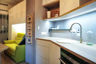 a kitchen with a sink and a green couch at 33 Paveestraße in Eupen
