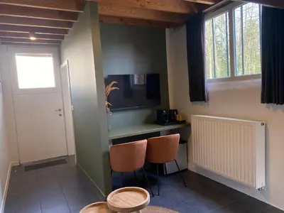 a room with two chairs and a desk with a television at Landgoed De Hoogmolen in Oudsbergen