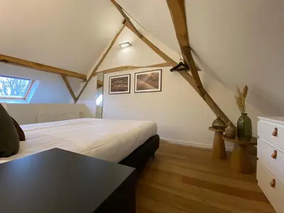 a bedroom with a bed and a table in it at Landgoed De Hoogmolen in Oudsbergen
