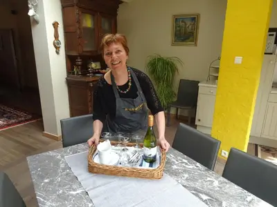 a woman sitting at a table with a basket of food at Stadshuisje 36 in Hasselt