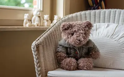 a brown teddy bear sitting in a wicker chair at Stadshuisje 36 in Hasselt