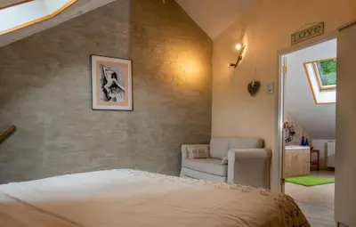 a bedroom with a bed and a chair at Stadshuisje 36 in Hasselt