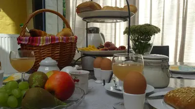 a table with eggs and bread and a basket of fruit at Stadshuisje 36 in Hasselt