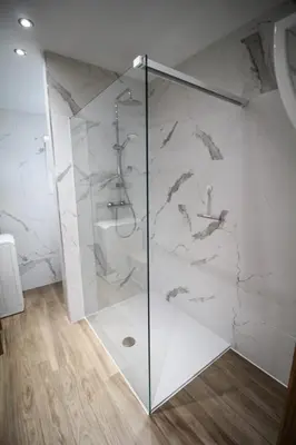 a shower with a glass door in a bathroom at LA BINAMERIE in Remicourt