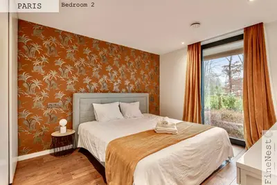 a bedroom with a bed with a orange wall at Résidence de 3 appartements luxueux - 2 ch x 3 - 