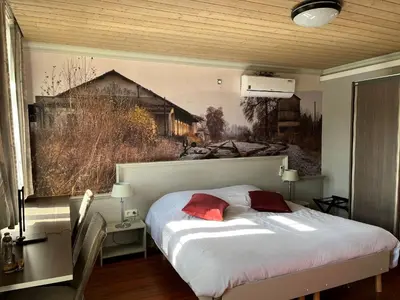 a bedroom with a bed with a painting on the wall at Gasthof De Statie in Wilderen