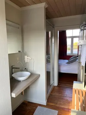 a bathroom with a sink and a bed and a mirror at Gasthof De Statie in Wilderen