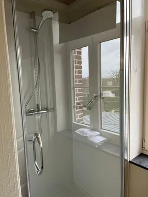 a bathroom with a glass shower with a window at Gasthof De Statie in Wilderen