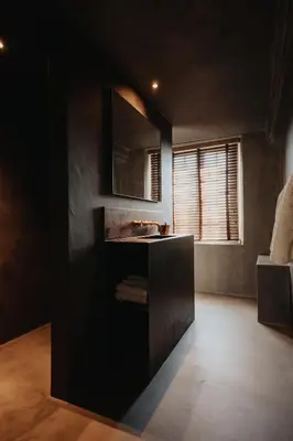a black bathroom with a sink and a mirror at Amitié in Kinrooi