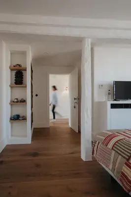 a woman walking through a room with a bed at Amitié in Kinrooi