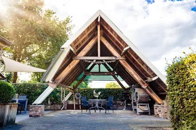 a tent with a table and chairs on a patio at Bij de Zöster in Kinrooi