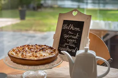 a pizza sitting on a table next to a sign at Vakantiewoning ‘t Reigersnest in Zonhoven